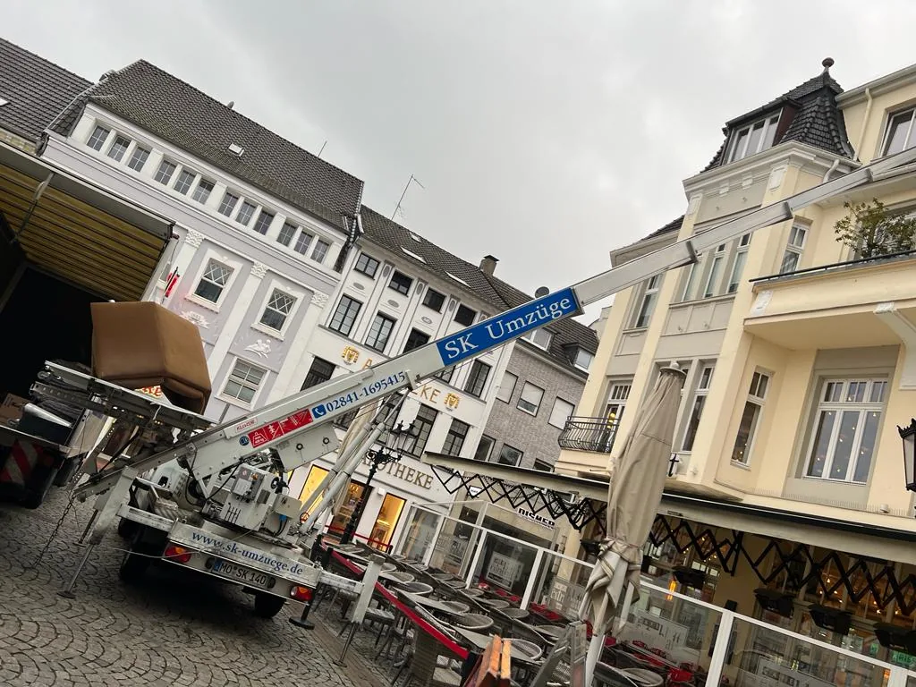 Möbellift von SK-Umzüge mit Möbelstück vor einem Altbau